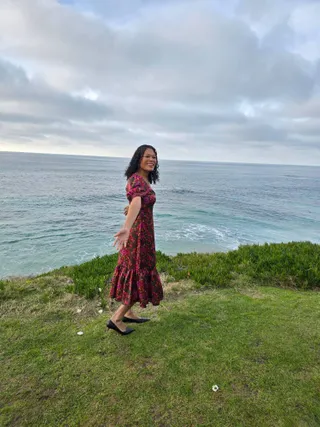 Euri smiling on the grass above the ocean