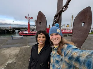 Jereme and Euri taking a selfie in front of the anchor and the Lightship Columbia