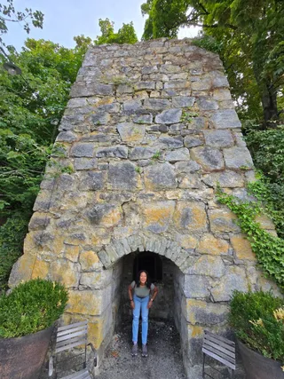 Euri standing in the arched opening of an old stone lime kiln