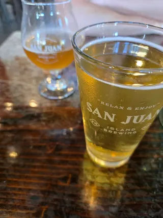 Two beers in San Juan Island Brewing glasses on a wooden table