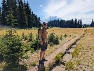 Jereme on the trail with Mount Rainier behind him